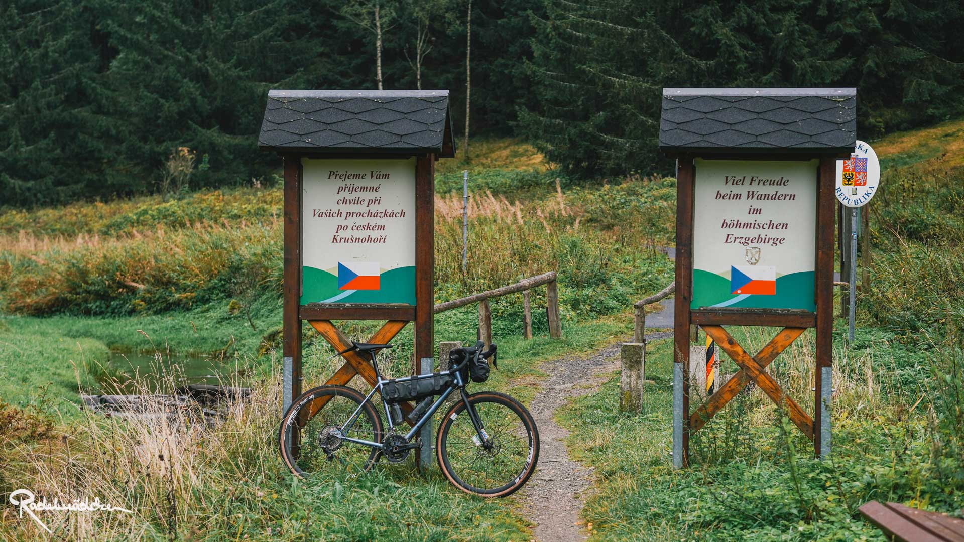Schilder an der tschechischen Grenze im Grünen mit Fahrrad
