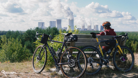 Fahrräder lehnen an einer Bank mit Ausblick auf Kraftwerk