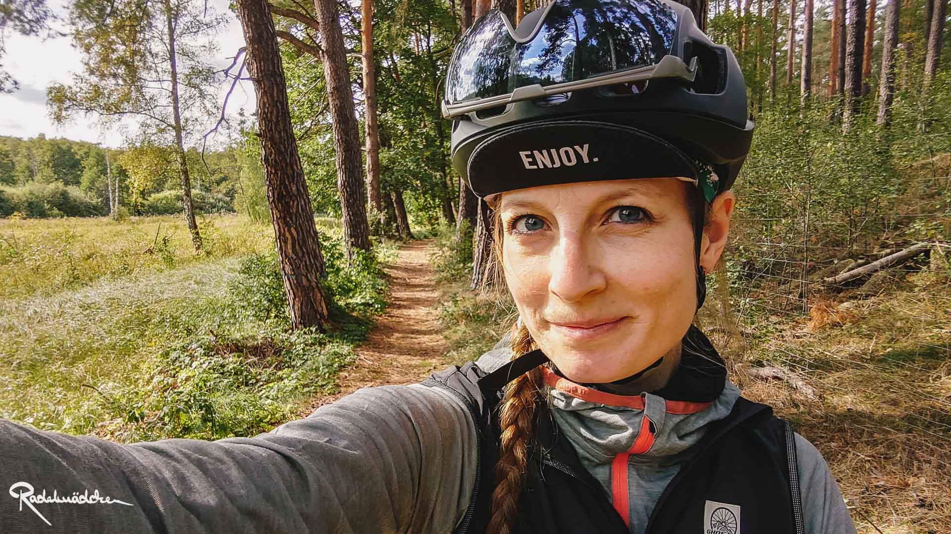 Jule mit Helm auf einem Waldweg
