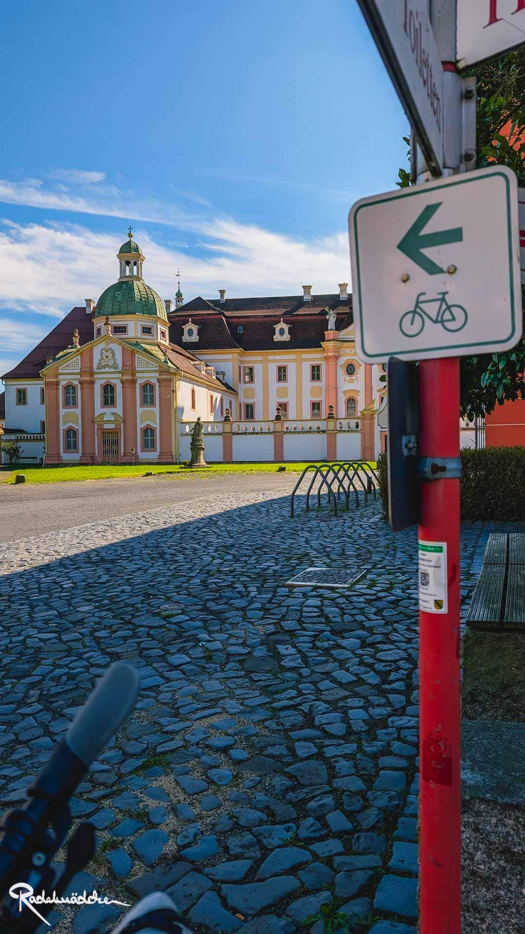 Fahrradschild und Kloster im Hintergrund