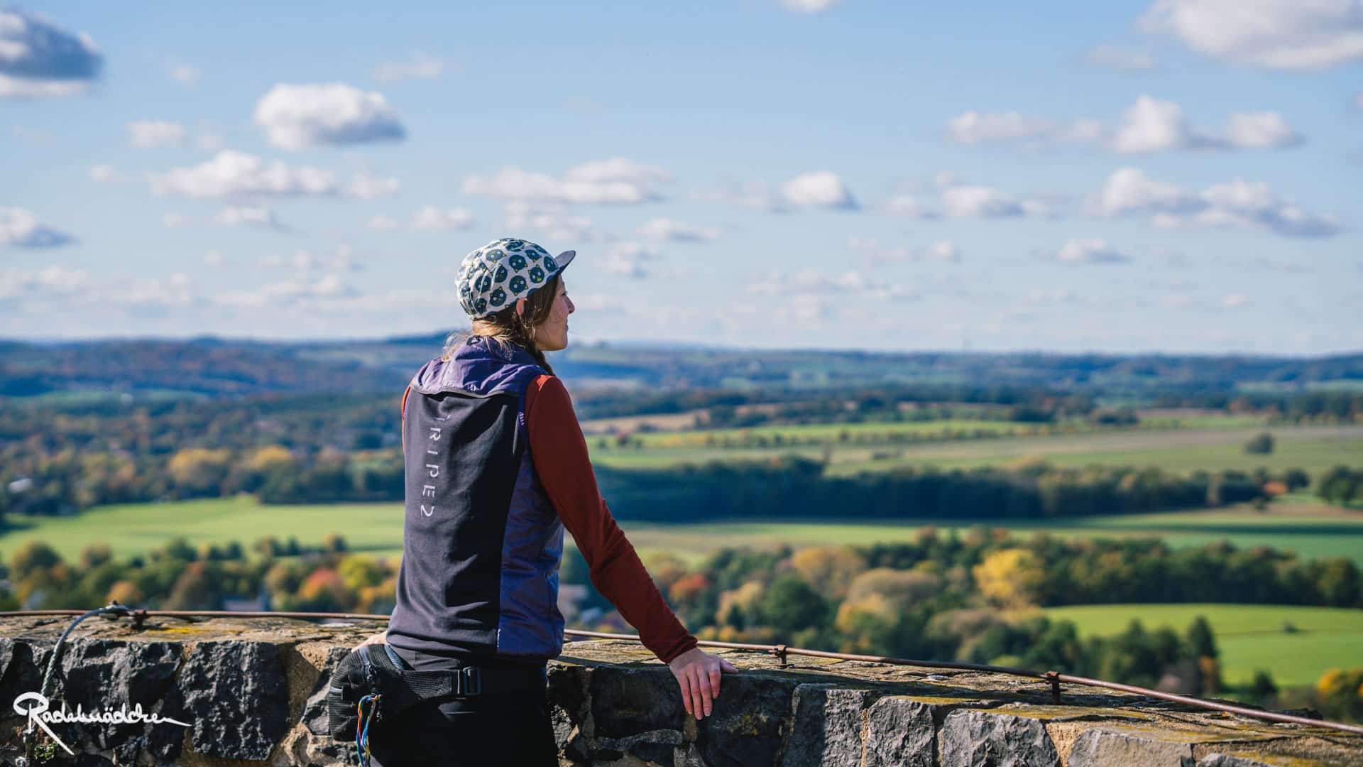 Frau schaut auf Landschaft an Mauer stehend
