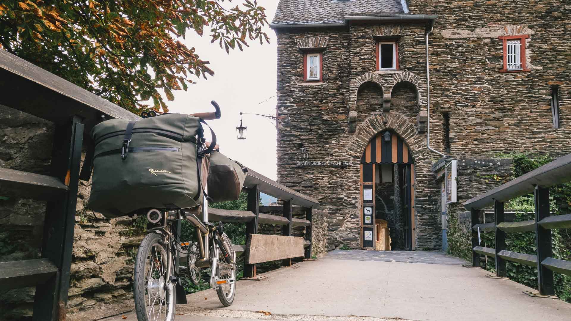 Radreise: Auf der Suche nach einer Unterkunft mit Bett + Bike Fahrrad vor Eingang zu einer Burg