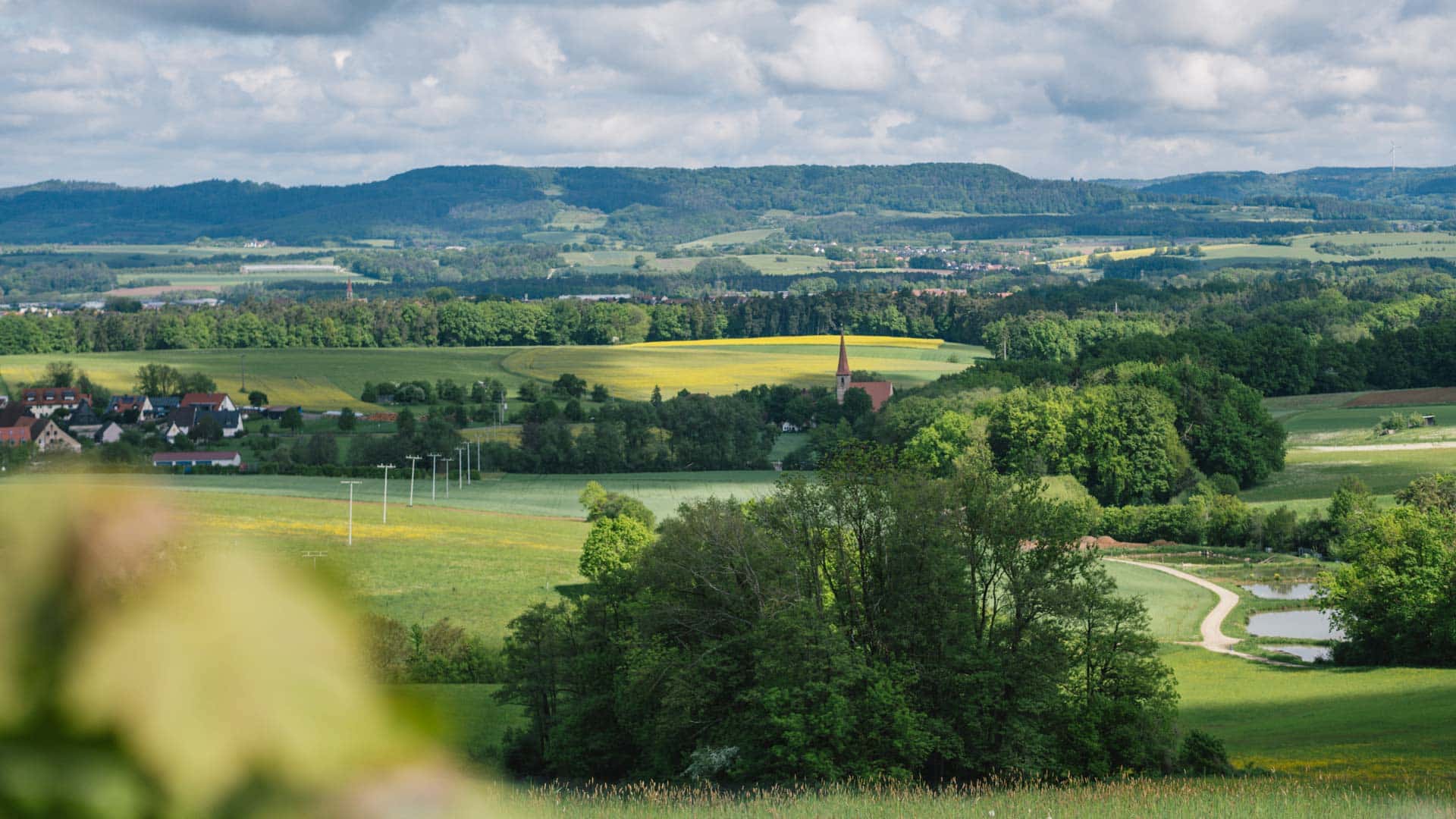 20 Fahrradtouren im Nürnberger Land Grüne Landschaft mit Bergen und Kirchturm