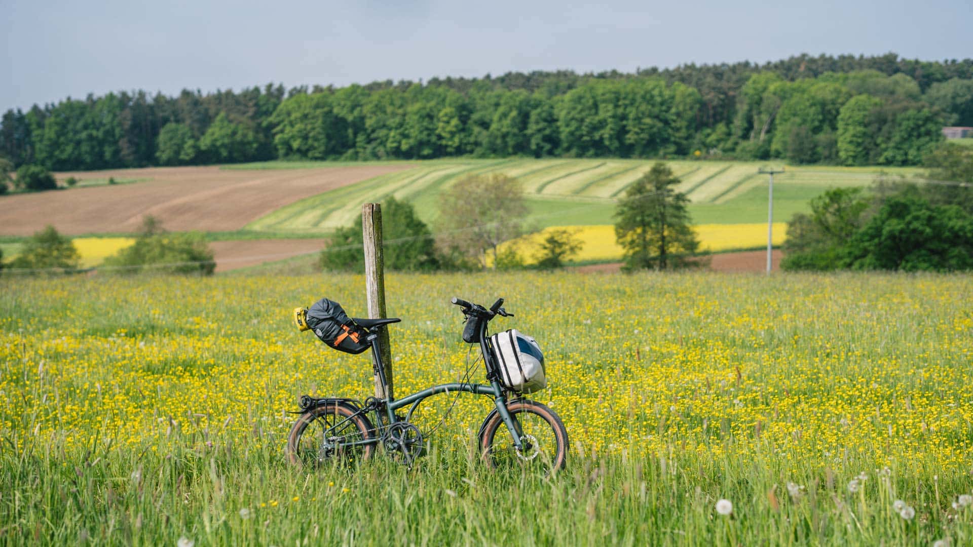 Brompton size up: von 16″ zur 20″ G-Line Fahrrad an Pfahl neben einem Feld